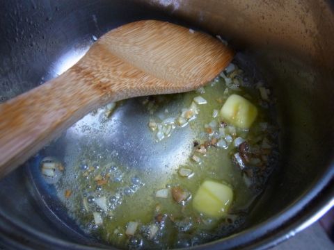 鍋にオリーブオイル大さじ1、バター約15g、みじん切りしたニンニク（1かけ分）を入れて中火で炒めます。