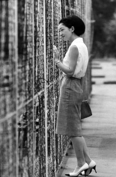 1964 8 1日　軽井沢ご静養にて、フェンス傍らに立ち恐らく陛下のテニスをご覧になっているところと思われる美智子さま。何気ないが優美な立ち姿である