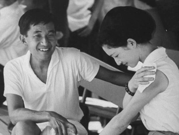 1964 8　軽井沢でテニスの際、ベンチで休む両殿下。美智子妃殿下は肩にハンカチをあてていらっしゃる。野次馬が大量にいるからか、皇太子殿下も苦笑い (7)